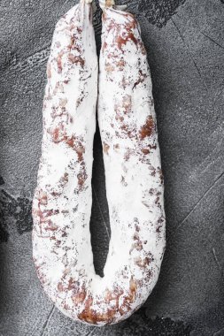 İspanyol kuru salamı, gri desenli arka planda bir raftan düz yatıyordu..