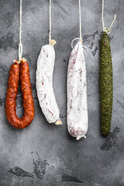 İspanyol kuru salamı, gri dokulu arka plandaki bir raftan..