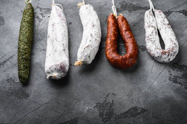 Gri arkaplan üzerinde bir raftan alınmış İspanyol kuru salamı..