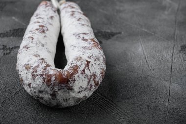 Gri arkaplanda kuru salam sosisi ve metin için yer var..