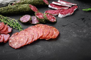 Kurumuş salam seti, İspanyol sosisleri, dilimler ve siyah desenli yüzey üzerinde metin için yer olan kesikler..