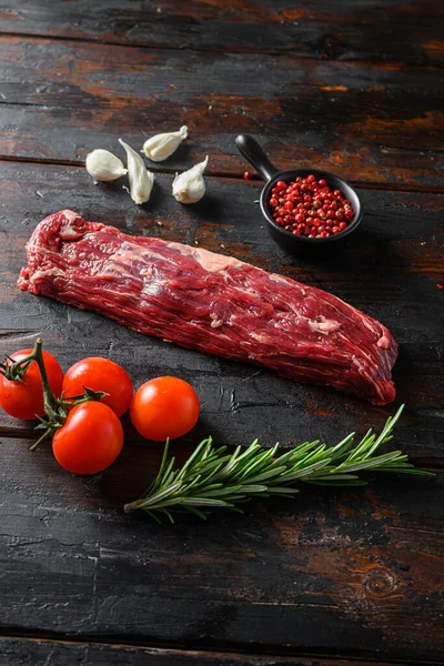 Machete steak raw cut  or hanging tende cut, with rosemary over wood background Top side view.