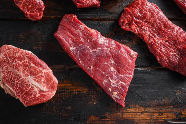 Biyo kanat bavette ya da biftek biftek biftek üç uçlu biftek ve üst bıçaklı istiridye kesikleri eski ahşap masa üst görüşünde kasaplık diğer kesiklerin önünde yakın.