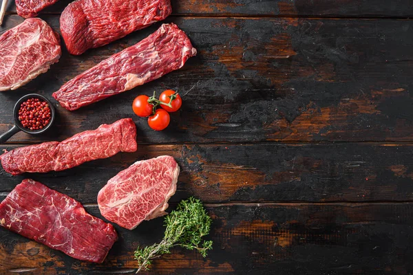 Set of  flap flank Steak, machete steak or skirt cut, Top blade or flat iron beef and tri tip, triangle roast with denver cut top view over old butcher wood table  space for text.