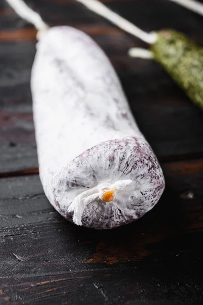 Koyu ahşap arka planda İspanyol Longaniza sosisleri.