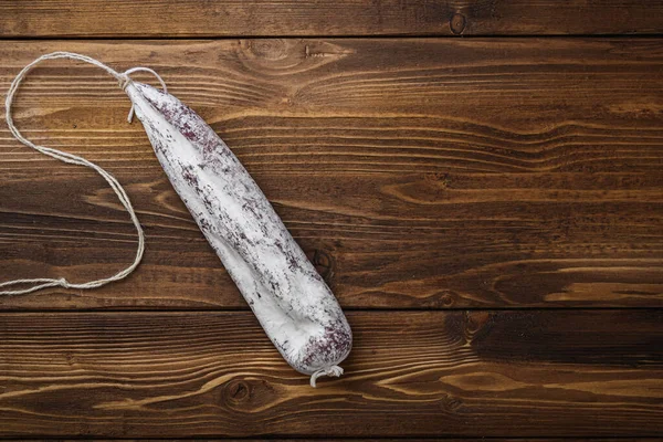 Longaniza fermente edilmiş beyaz sosis ahşap masada, üst görünümde metin için boşluk var.