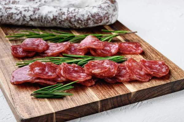 Beyaz desenli arka planda bütün ve dilimlenmiş İspanyol kuru sosisi..