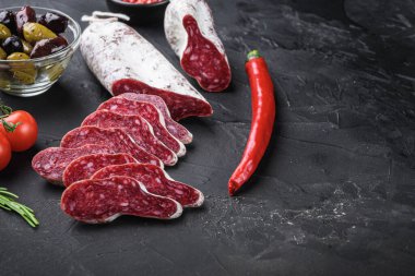 İspanyol Longaniza salam sosisi. Balck background üzerinde otlar ve fotokopi alanı ile dilimler..