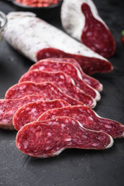 İspanyol Longaniza salamı sosis dilimleri ve siyah desenli arka grup otları..