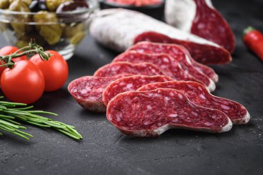 İspanyol Longaniza salamı sosis dilimleri ve balkabağı arka planında otlar..