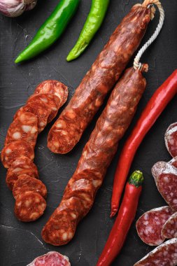 Çeşitli İspanyol kurutulmuş salam sosisleri dilimler ve balkon arka planda tüm kesikler, düz yatış.