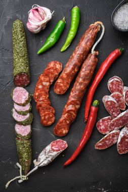 İspanyol kuru salam sosisleri dilimler ve siyah desenli arka plan, üst görünüm kesikleri..