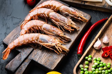 Siyah desenli arka planda paella için malzemeli kral karidesleri, yemek fotoğrafı..