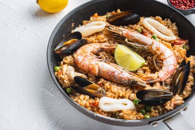 Paella kızartma tavasında, arka planda fotokopi alanı ve yemek fotoğrafıyla pişiriliyor..