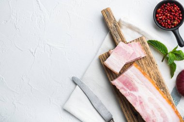 Pastırma pancetta beyaz arkaplanda otlarla kesilmiş ve dilimlenmiş, üst görünümü metin için alan.