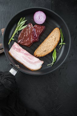 Izgara tavasında domuz pastırması dilimlenmiş sığır ciğeri..