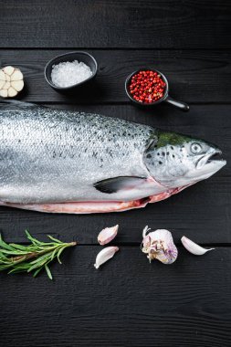 Siyah ahşap yüzeyde taze çiğ somon balığı..