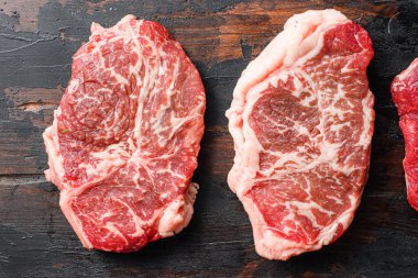 Eski ahşap kalasların üstünde biftekli biftek takımı.