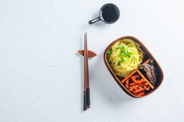 Kore yemeği, ızgara sığır eti ve Japon Bento yemeği. Yemek çubuklarıyla dolu.