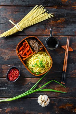 Kore yemeği, ızgara biftek ve Japon Bento yemeği. Yemek çubuklarıyla dolu. Eski ahşap masa.