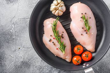 Gri arka planda çiğ organik tavuk ızgara tavası. Gıda hazırlama, üst görünüm metin için alanı kapat