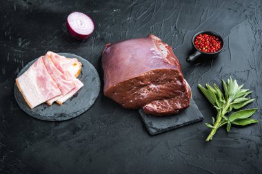 Siyah arka planda domuz pastırmalı sığır ciğeri..