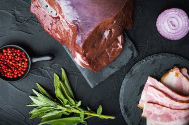 Siyah arka planda domuz pastırmalı sığır ciğeri..