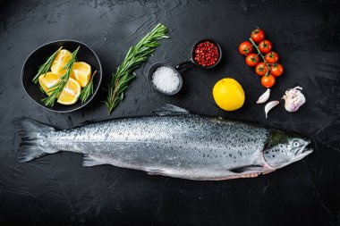 Siyah arka planda tüm ham somon balığı, üst görünüm.