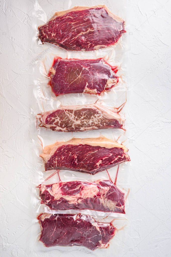 Set  of  vacuum packed organic raw beef alternative cuts: top blade, rump, picanha, chuck roll steaks, over white background, top view