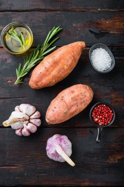 Eski ahşap masanın üzerinde bitkilerle birlikte çiğ patates..