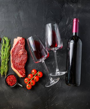 Kırmızı şarap ve cam şişeli Picanha bifteği, siyah desenli arka planda üst manzara. Kare büyük ekin boyutu