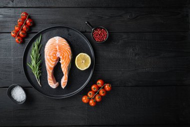 Siyah ahşap yüzeyde otlu balık çiğ fileto, metin için en üstten manzara.