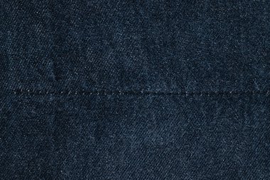 Koyu mavi kotun doku detayları, arka planda dikişleri olan tekstil..