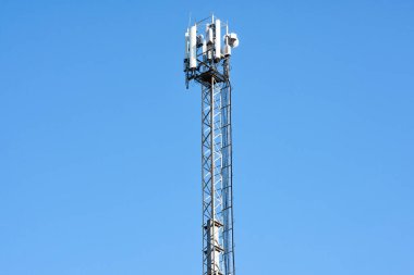 Mavi gökyüzünün arka planındaki hücresel anten kulesi.