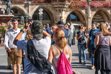 MUNİK, Almanya - 12 Eylül 2018: Münih 'teki Marien Platz' de akıllı telefonlarla fotoğraf çeken turistler.