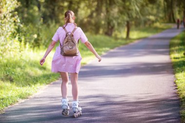 Yaz günü parkta paten kayan kız..