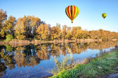 Güzel sıcak hava balonları sabah erkenden nehrin üzerinde mavi gökyüzünde.