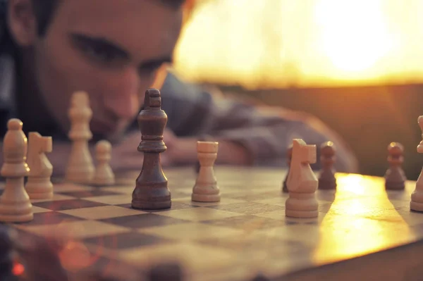 Young Man Looks Chessboard — Stock Photo, Image