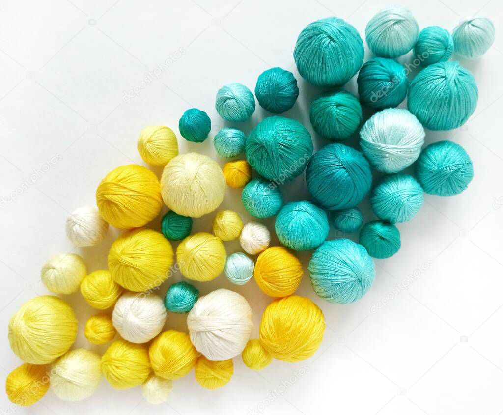 Yellow and blue balls of yarn isolated on white background