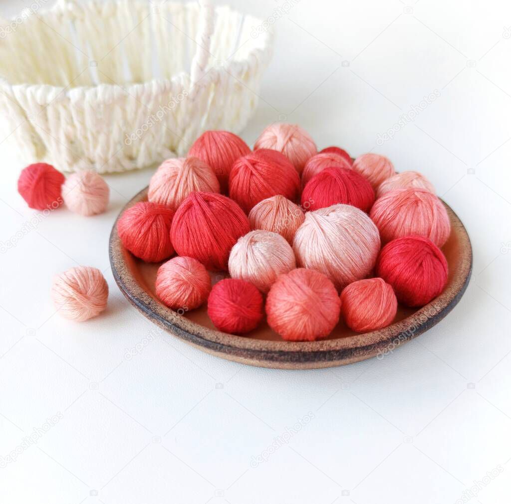 Basket with red yarn for knitting. Red threads for needlework.