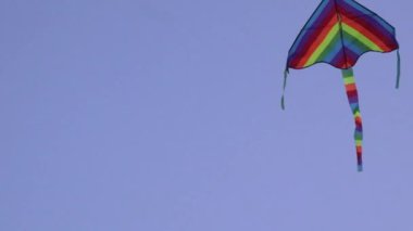 Yazın gökyüzünde uçan renkli uçurtma ve neredeyse yere düşüyordu, ama tekrar havalandı. 
