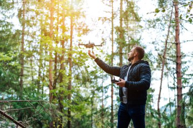 adam bir quadrocopter ormanda başlar.