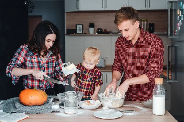 Папа, мама и маленький сын готовят пирог. — стоковое фото