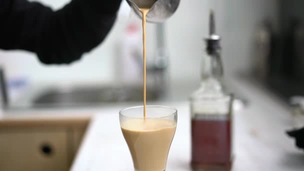 Бариста наливает кофе с молоком в стакан — стоковое видео