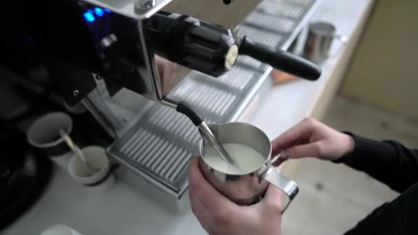 Barista stomen van de melk in een RVS-tuimelaar — Stockvideo