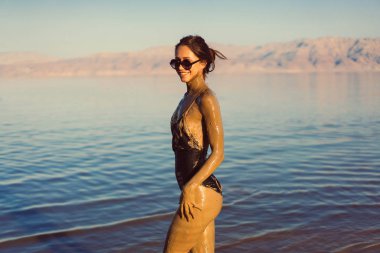 Genç bir kadın doğal mineral çamurunun tadını çıkarıyor.