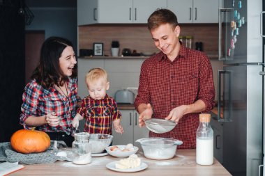 Baba, anne ve küçük oğlu bir pasta yemek