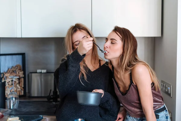 Duas meninas comem mingau em casa — Fotografia de Stock