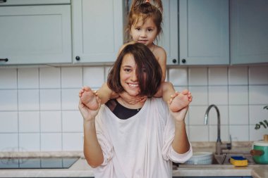 Güzel küçük kızım mutlu annesini sırtında taşıyor.