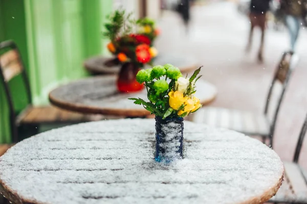 Blommor står på ett snöigt bord — Stockfoto